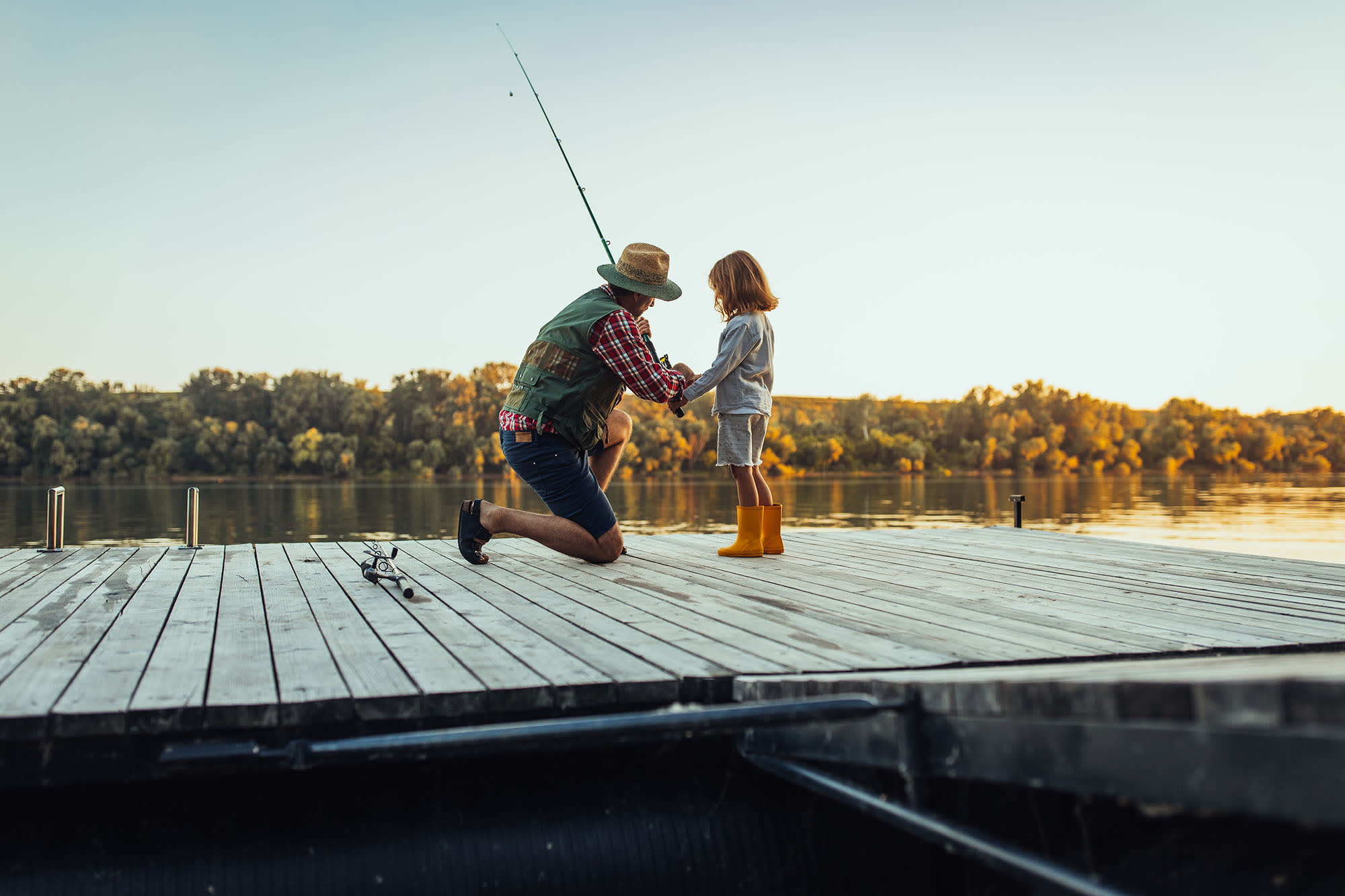 Father and child fishing from a dock.