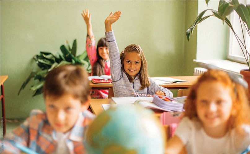Kids in school raising their hands