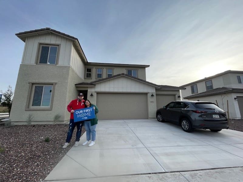 First-time homebuyers in front of their new homes