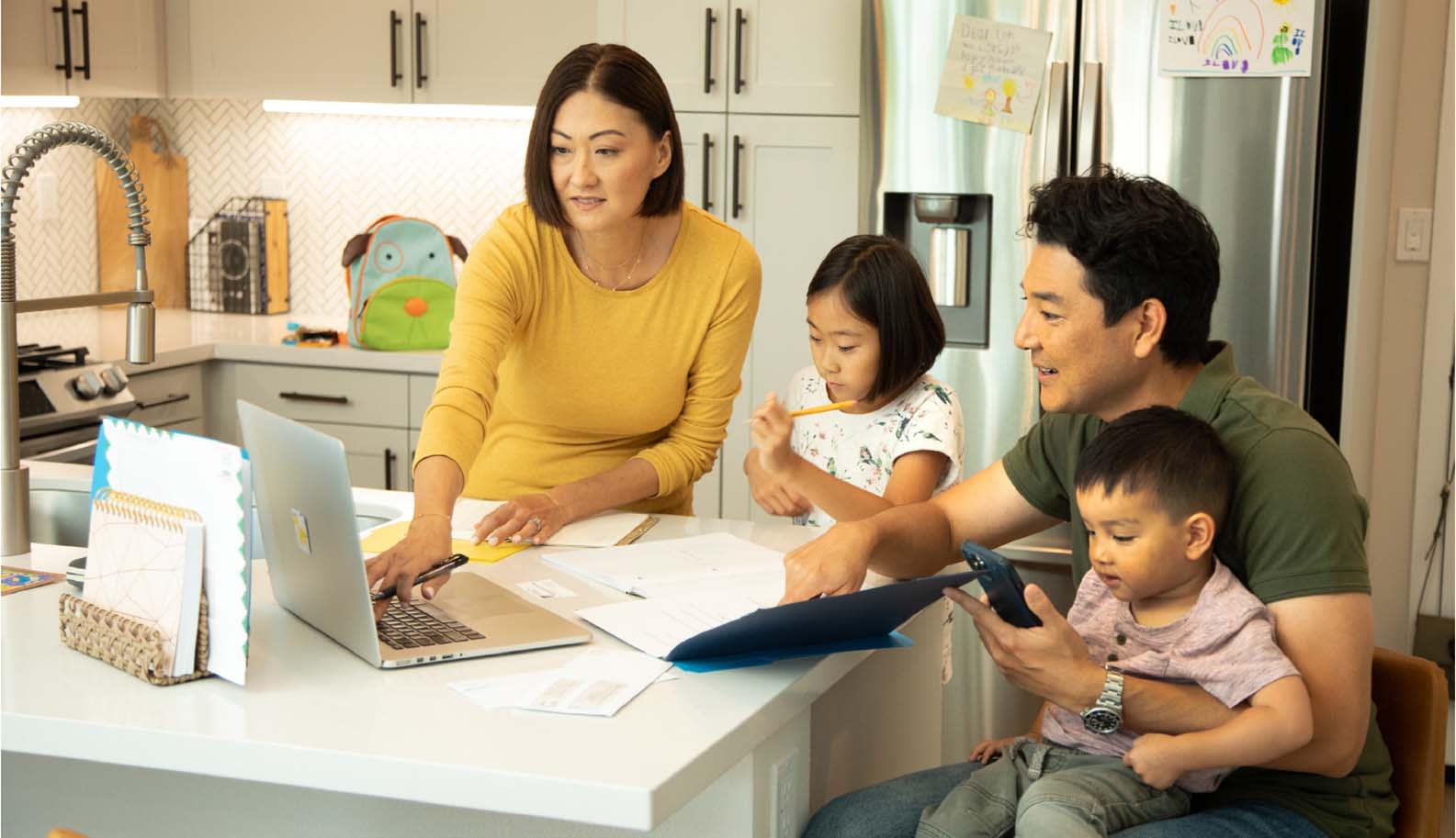 family looking at the laptop in kitchen